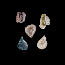 a-group-of-5-(five)-early-islamic-glass-vessel-stamps,-two-examples-moulded-in-the-form-of-a-human-face-and-example-with-arabic-calligraphy_08536c